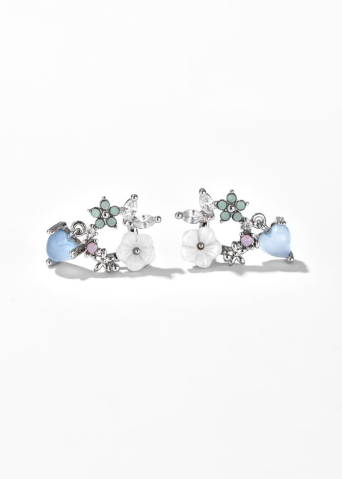 Floral heart earrings with white flower petals, and small crystals.