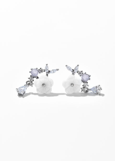 A pair of floral earrings with clear gemstones on a silver-tone metal.