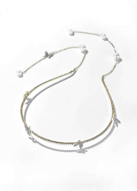 White pearl headband with butterfly accent evenly spaced along the band.