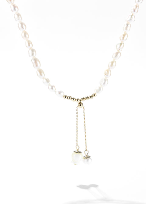 Freshwater pearl necklace forming a chain and a small flower pendant hanging from a gold chain.