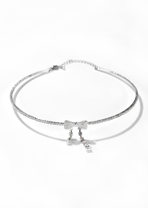 A bow choker necklace with hanging clear crystal details.