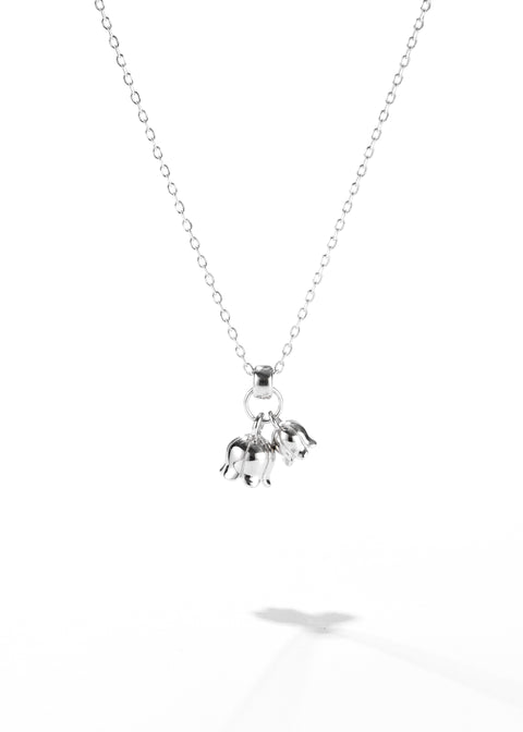A dainty flower necklace featuring three small floral charms hanging from a chain.