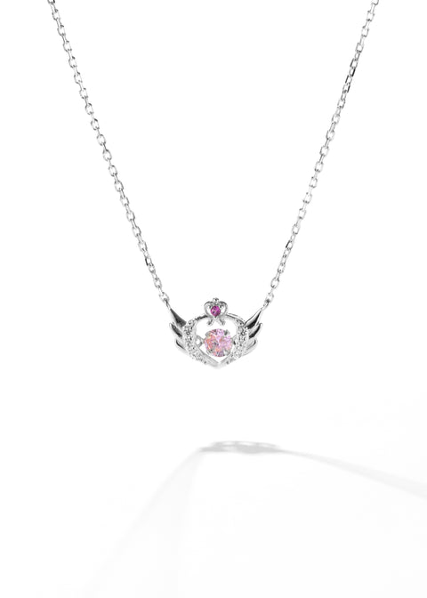 A gold angel wing necklace with a heart-shaped pendant, embellished with pink crystals.