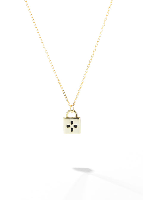 A padlock pendant necklace featuring with a black four-petal flower design on it, suspended on a gold chain.