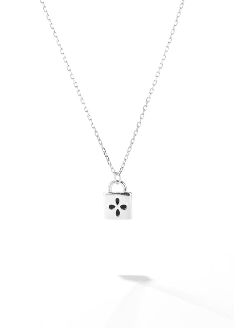 A padlock pendant necklace featuring with a black four-petal flower design on it, suspended on a white gold chain.