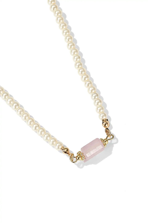 This pearl with pendant necklace features a string of shiny pearls with a soft stone in the center.