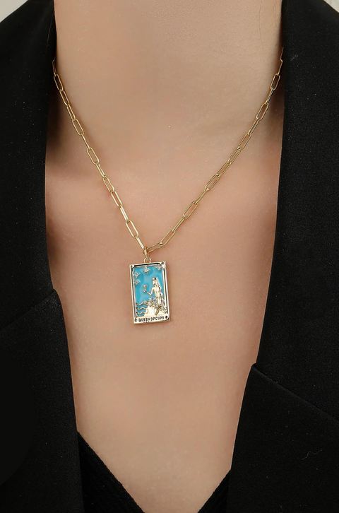 A tarot card necklace featuring a rectangular pendant inscribed at the bottom.