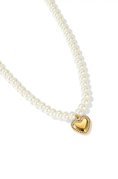A heart pearl necklace with shiny pearls and a gold heart pendant.