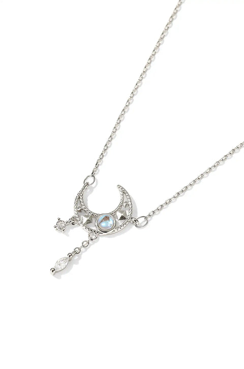 A tassel necklace featuring a crescent moon pendant with stars and an opalescent stone.