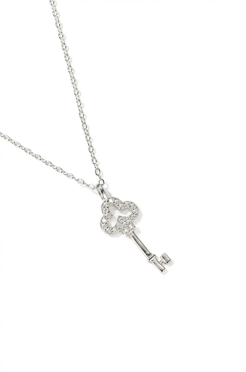 A gold key necklace with a heart-shaped top encrusted with small diamonds.