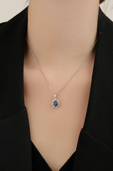 This blue stone necklace has a pendant showcasing a deep blue gem surrounded by small crystals.