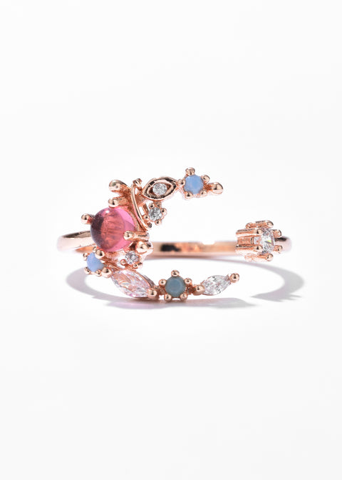A crescent moon ring design with an open ring style and set with various sized gemstones.