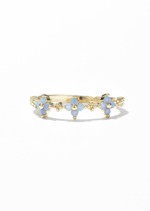 Flower ring with a scalloped design, featuring small blue flowers made of gemstones, creating a delicate, petal-like pattern around the band.