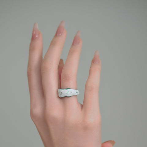 A wavy-shaped unique ring with a glossy finish, a statement ring accented by swirls and gold embellishments.