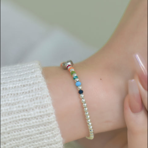 A smiley face bracelet with a sequence of small, colorful beads all around.