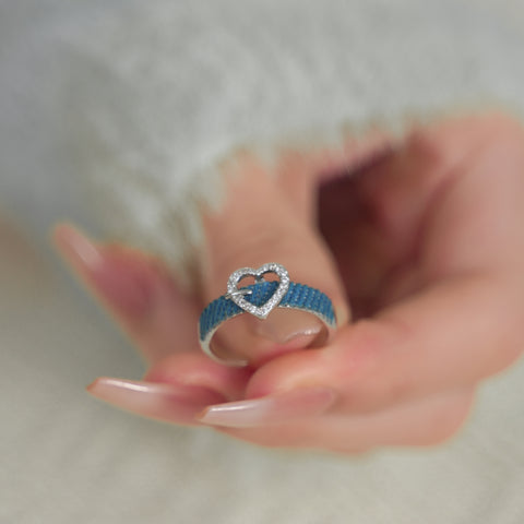 A heart shaped ring with a denim band setting encrusted with sparkling small stones.