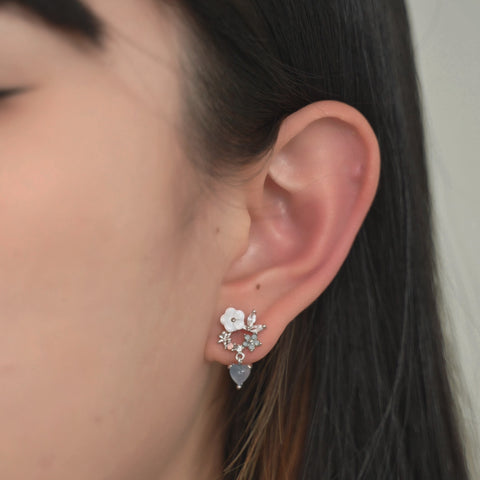Floral heart earrings with white flower petals, and small crystals.