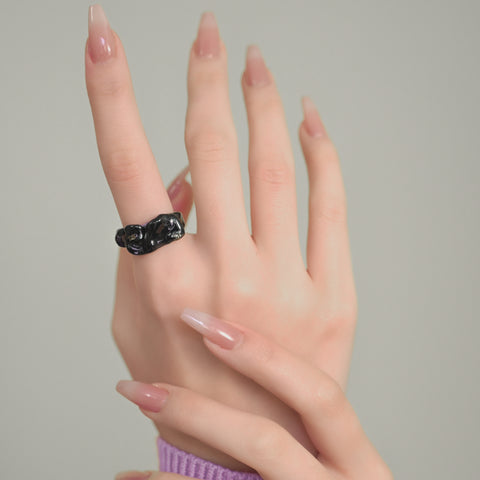 A wavy-shaped unique ring with a glossy finish, a statement ring accented by swirls and gold embellishments.