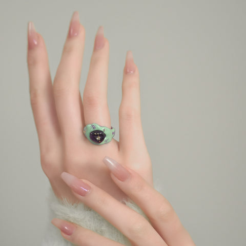 A wavy-shaped unique ring with a glossy finish, a statement ring accented by swirls and gold embellishments.