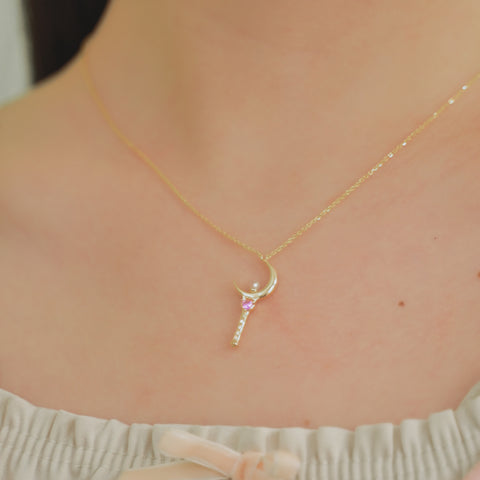 This sailor moon necklace has a pendant with a crystal orb hanging from a gold chain.