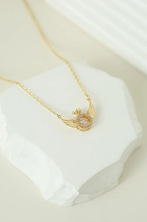 An angel wing necklace featuring central, sparkling gem surrounded by smaller crystals.