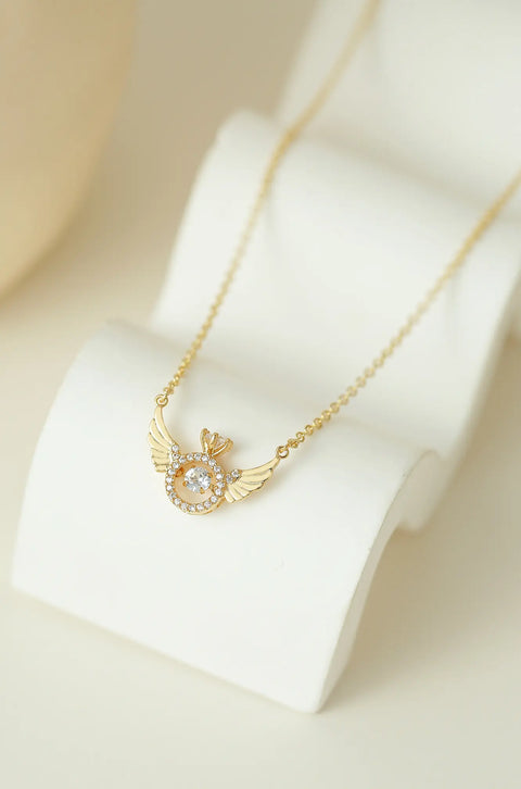 An angel wing necklace featuring central, sparkling gem surrounded by smaller crystals.