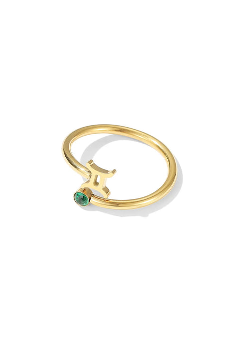 Gemini ring jewelry in gold featuring the zodiac symbol adorned with a small green gemstone.