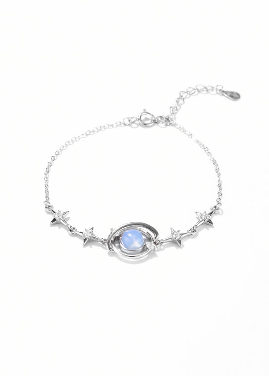 Silver bracelet with a central, round blue moonstone and small star shapes on both sides.