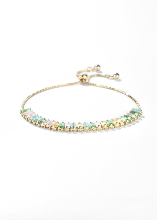 An emerald bracelet with a series of rectangular stones, set in an adjustable bracelet design.