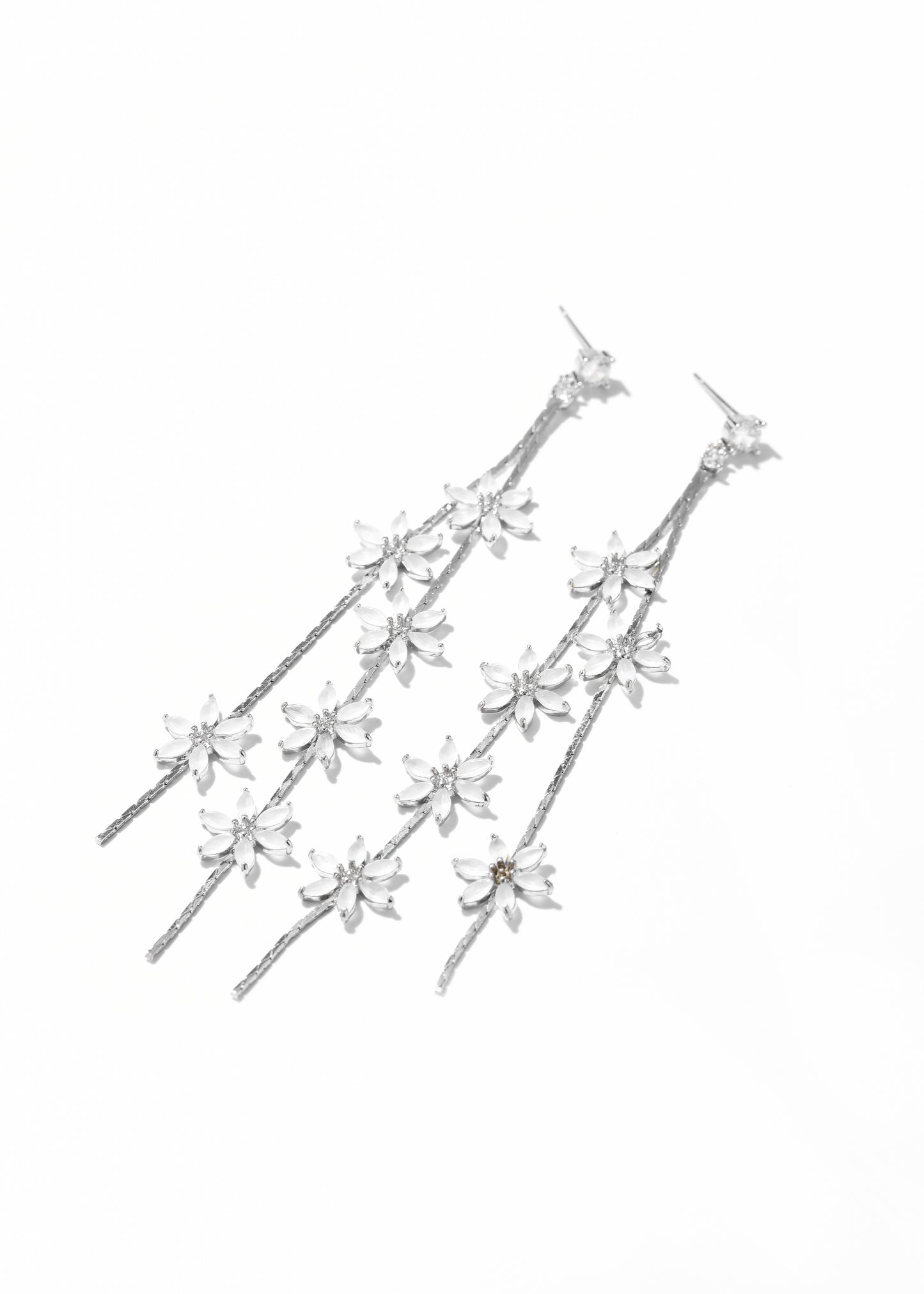 A long drop earrings with multiple small, sparkling floral earrings design trailing down.