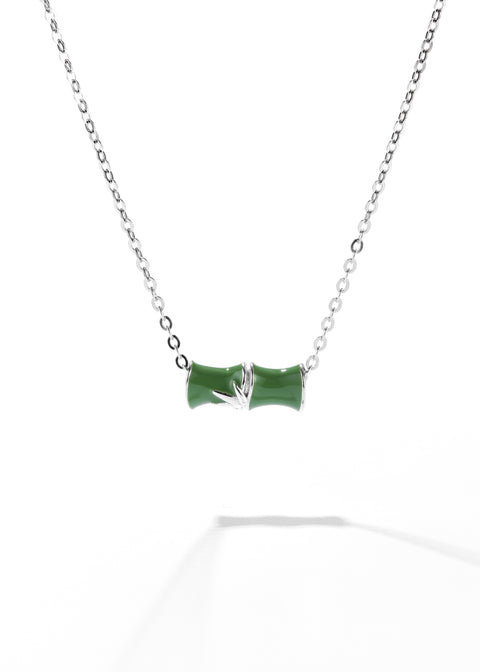 A horizontal bamboo-shaped pendant necklace, painted in glossy green enamel and set between two silver caps on a sterling silver chain.