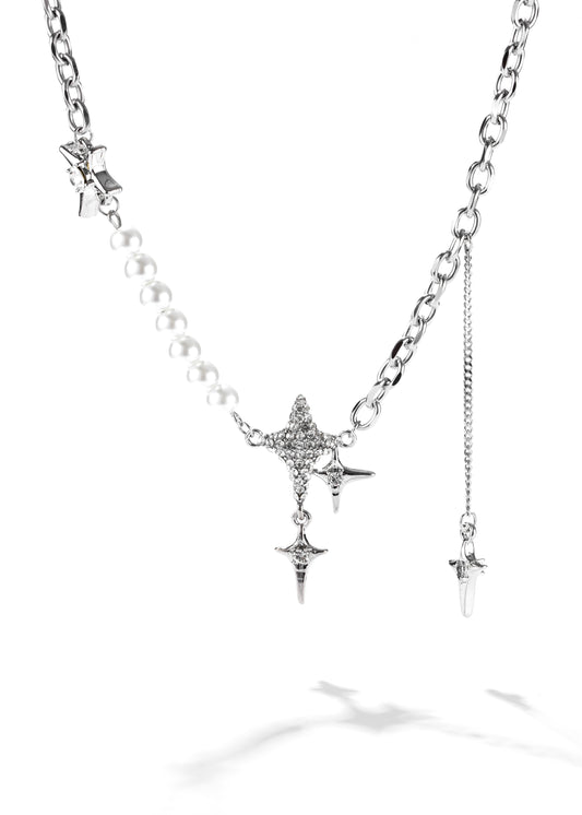 A constellation necklace with star pendant a strand of pearls, creating a lariat style.