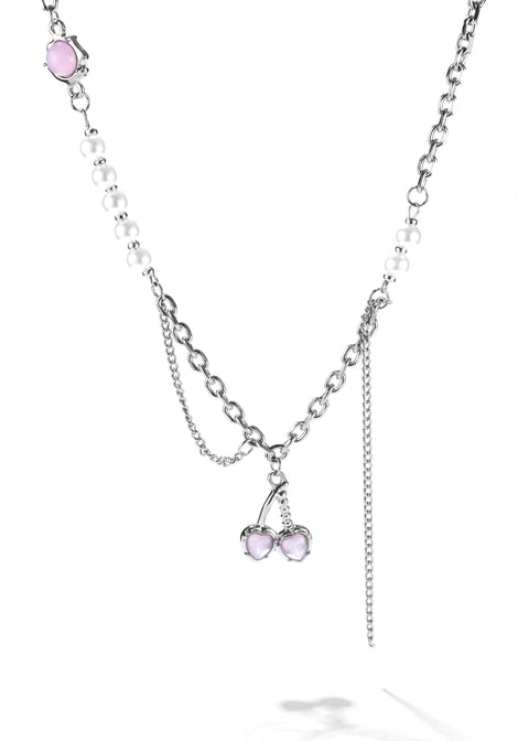 Cherry necklace in silver chain and a strand of white pearls, leading to a pink heart pendant.