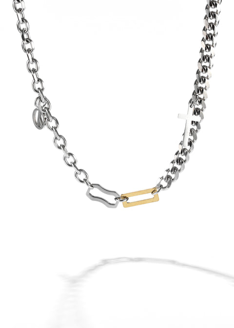 A Cuban link chain necklace and small silver and gold bar pendant as a highlight.
