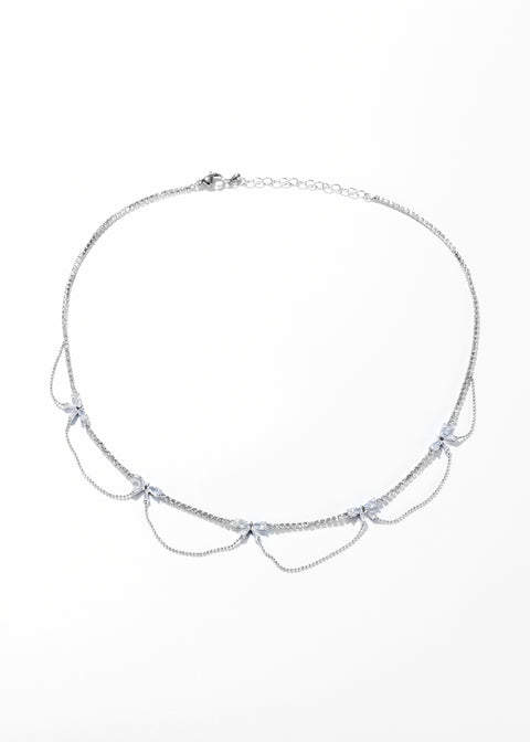 A silver bow knot necklace choker with a chain design, featuring small, shining crystals at intervals.