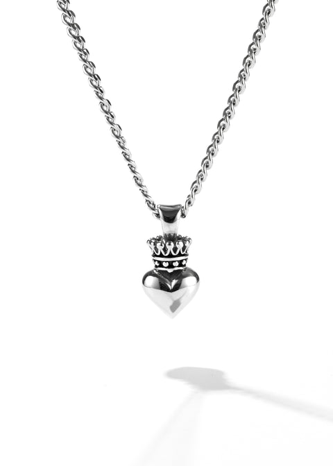 A silver chain necklace, holding a heart pendant topped with a small crown.