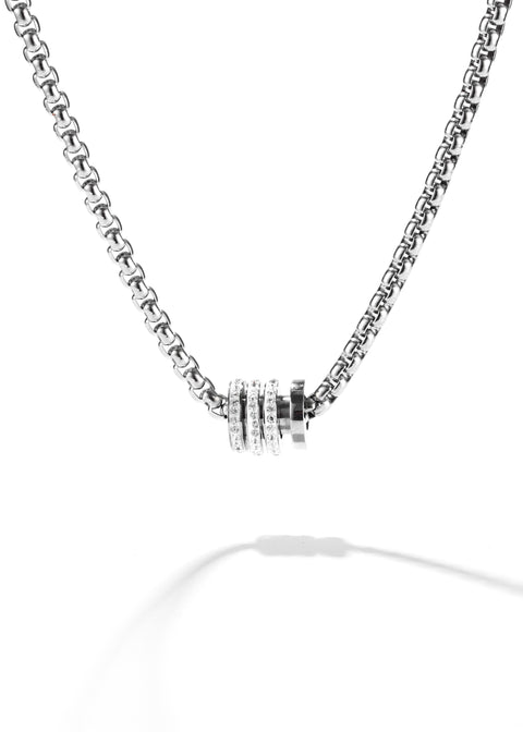 A thick chain necklace with a crystal-studded ring pendant clustered together.