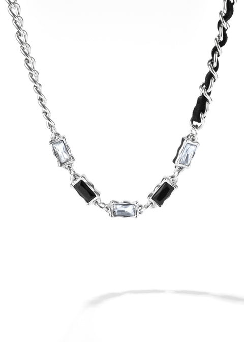 A gem leather necklace with a chain, interspersed with clear and black gemstones.