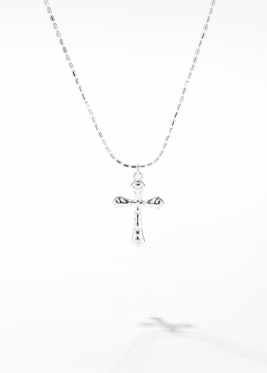 A silver cross necklace with a simple chain and a distinctive cross pendant.