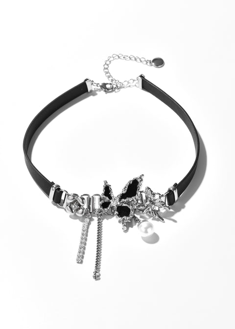 A butterfly collar with a black band, complemented by a mix of shiny elements, a hanging pearl charm, and chain tassels.