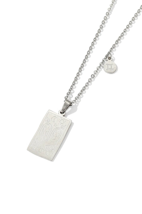 A Gemini necklace featuring rectangular pendant with floral design, and a smaller, round charm with the zodiac sign.