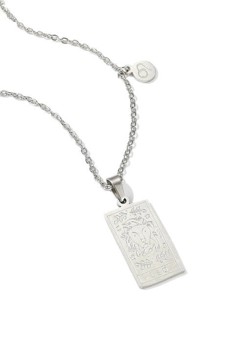 A Leo necklace featuring rectangular pendant with floral design, and a smaller, round charm with the zodiac sign.