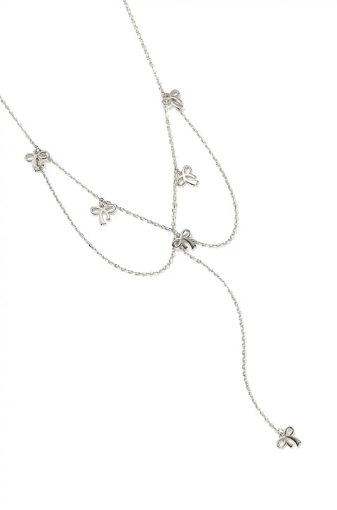 A silver bow necklace featuring small bow charms evenly spaced on a chain.