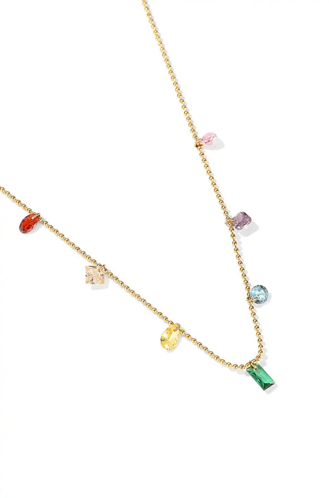 A rainbow gem necklace with various colorful gemstones on a gold chain.