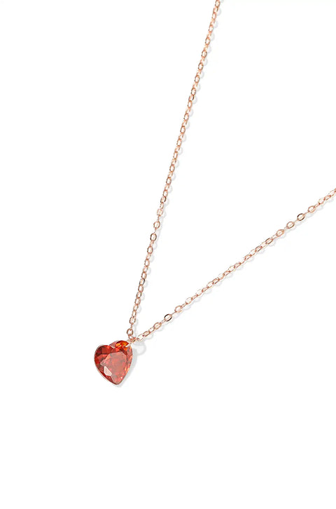 A red heart necklace with sparkling pendant on a chain.