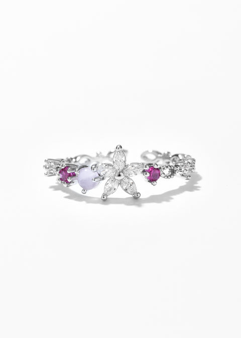 An open ring with a flower petal design and small gemstones on each side.