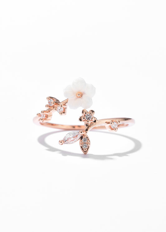 A rose gold open ring featuring a floral ring design, complemented by small crystal details along the petals and band.