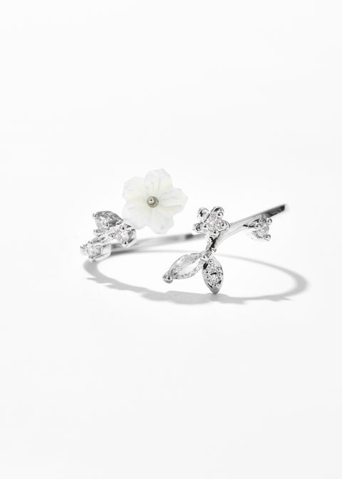 A silver open ring featuring a floral ring design, complemented by small crystal details along the petals and band.