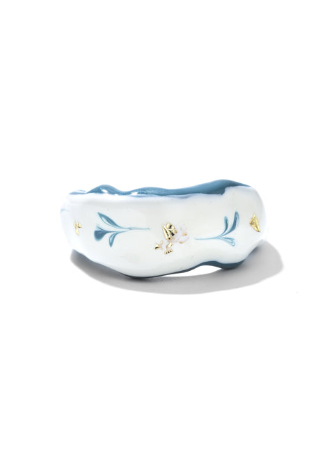 A wavy-shaped unique ring with a glossy finish, a statement ring accented by swirls and gold embellishments.