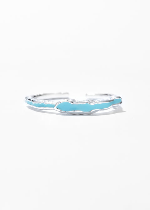 A wavy drip ring with a glossy turquoise enamel inlay.